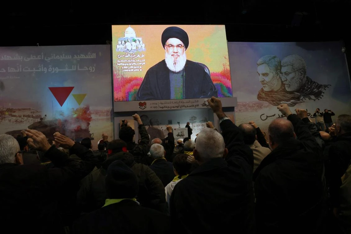 People watch the televised speech of Lebanon’s Hezbollah chief Hasan Nasrallah to mark the anniversary of the killing of slain top Iranian commander Qasem Soleimani, in a Beirut’s southern suburb on January 3, 2024. (AFP)