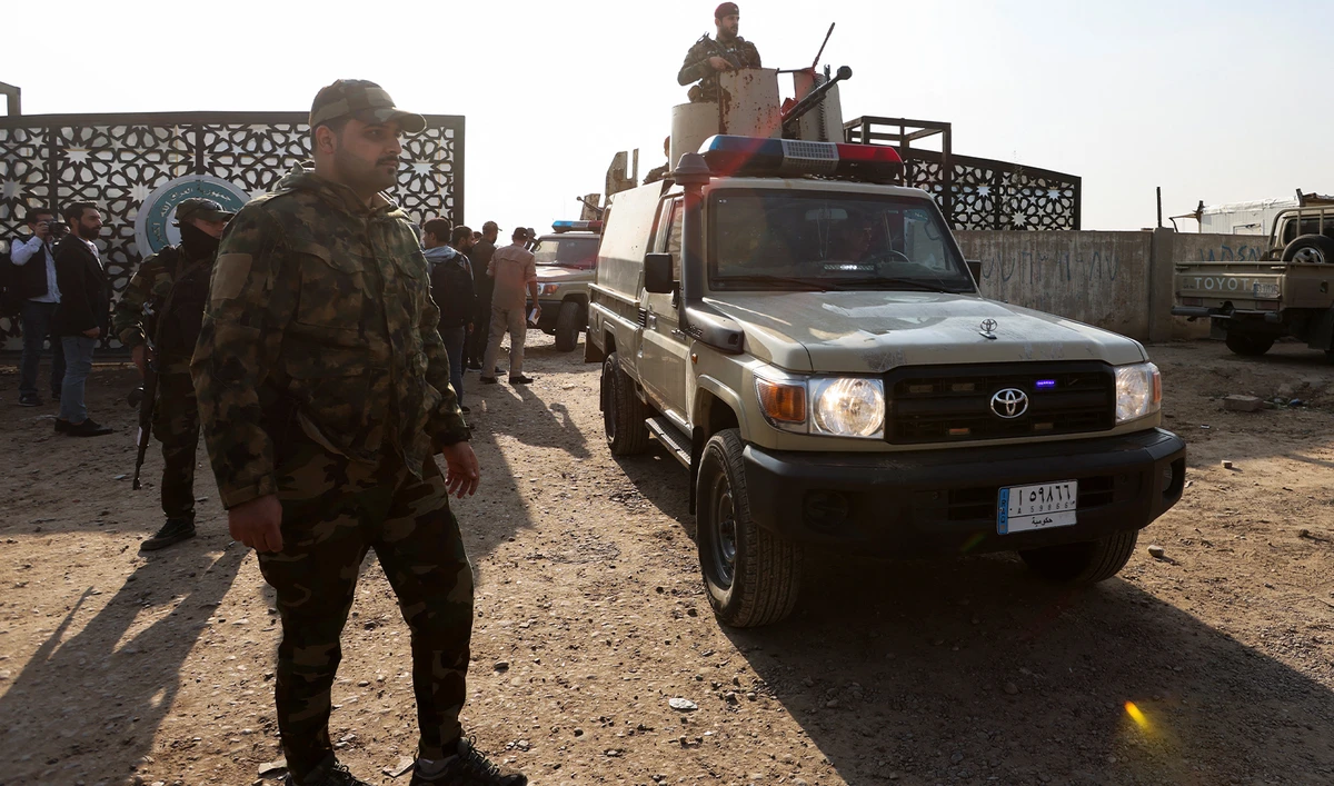 Members of an Iraqi Shi'ite armed group sit in a vehicle after an attack by a drone strike on an Iran-backed militia headquarters in Baghdad, Iraq, on January 4, 2024. (REUTERS)