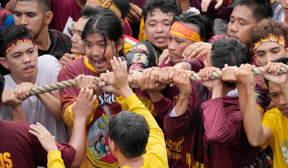Devotees grab the rope as they pull the glass-covered cart carrying Black Nazarene during its annual procession which was resumed after a three-year suspension due to the coronavirus pandemic on Tuesday, Jan. 9, 2024 in Manila, Philippines. (AP)