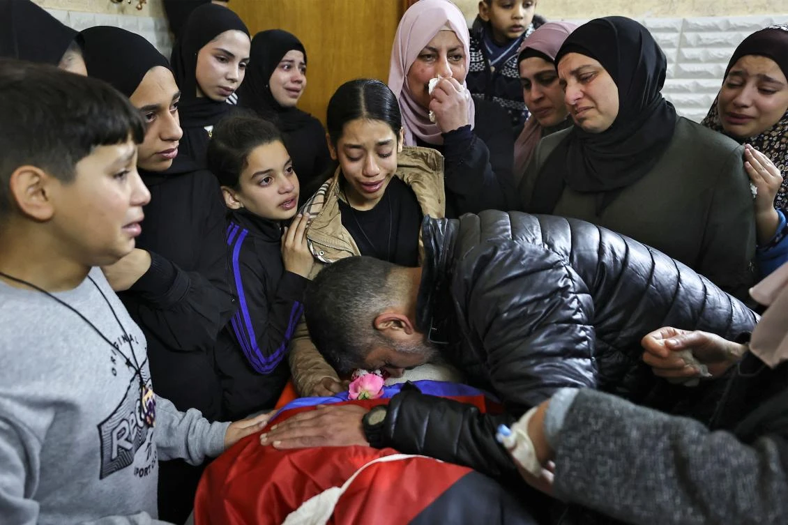 Relatives mourn over the body of a man killed during an overnight Israeli raid on the Tulkarem refugee camp in the occupied West Bank on Jan. 9, 2024. (AFP)