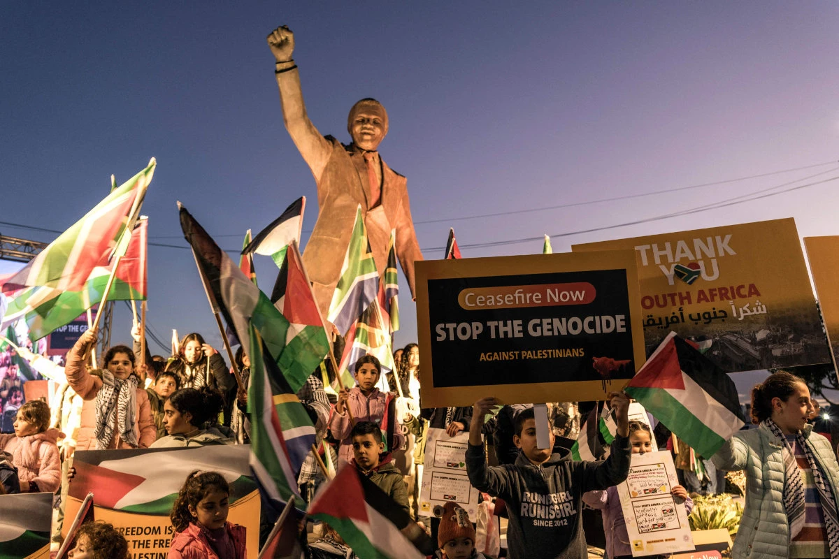 Palestinians gather around a statue of the late South African president Nelson Mandela in the occupied West Bank city of Ramallah on January 10, 2024, to celebrate a landmark "genocide" case filed by South Africa against Israel at the International Court of Justice. (AFP)