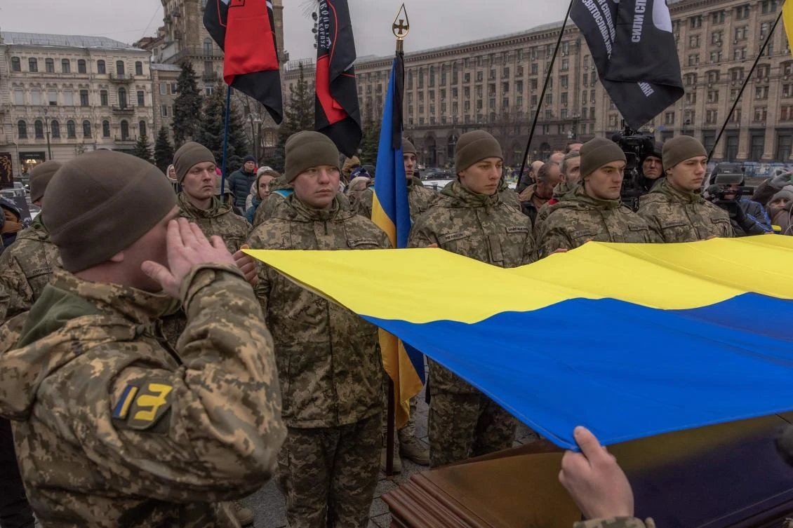 Ukrainian servicemen hold a national flag over a coffin of a Ukrainian poet and serviceman Maksym Kryvtsov who was killed on the frontline, at the Saint Michael’s Golden-Domed Monastery in Kyiv, on Jan. 11, 2024. (AFP)