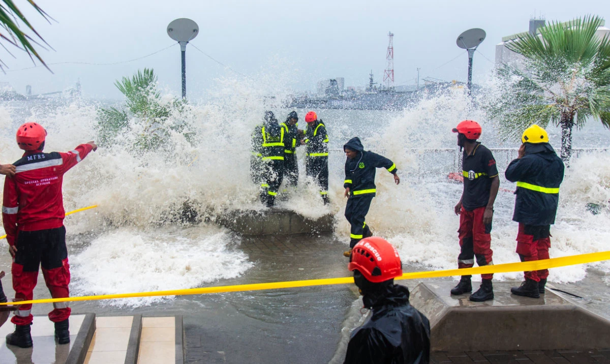 Workers are covered in water from a wave during a cyclone on the Caudan Waterfront in Port Louis, the capital city of Mauritius, Monday Jan. 15, 2024. (AP)