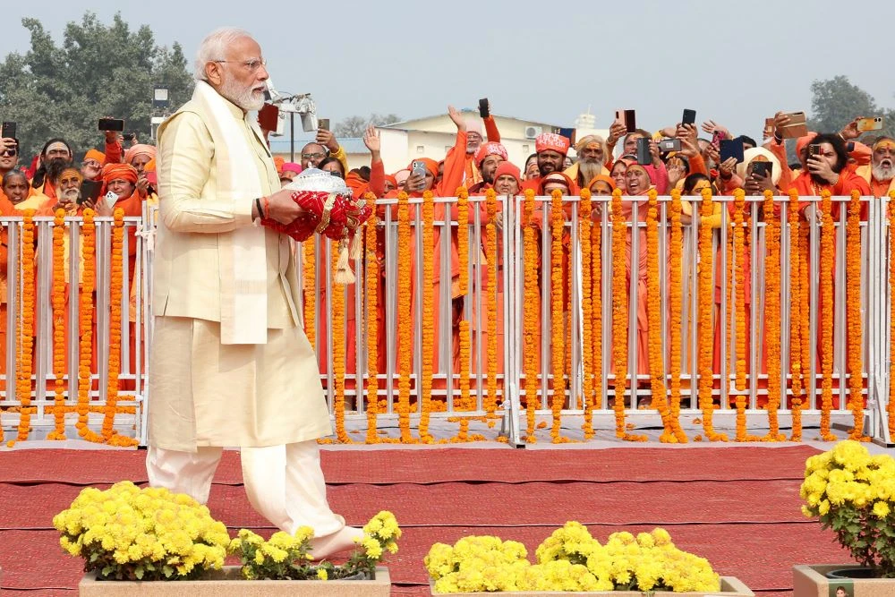 India’s Prime Minister Narendra Modi carries an offering as he walks towards the temple stairs to officially consecrate the Ram temple in Ayodhya in India’s Uttar Pradesh state. (AFP)