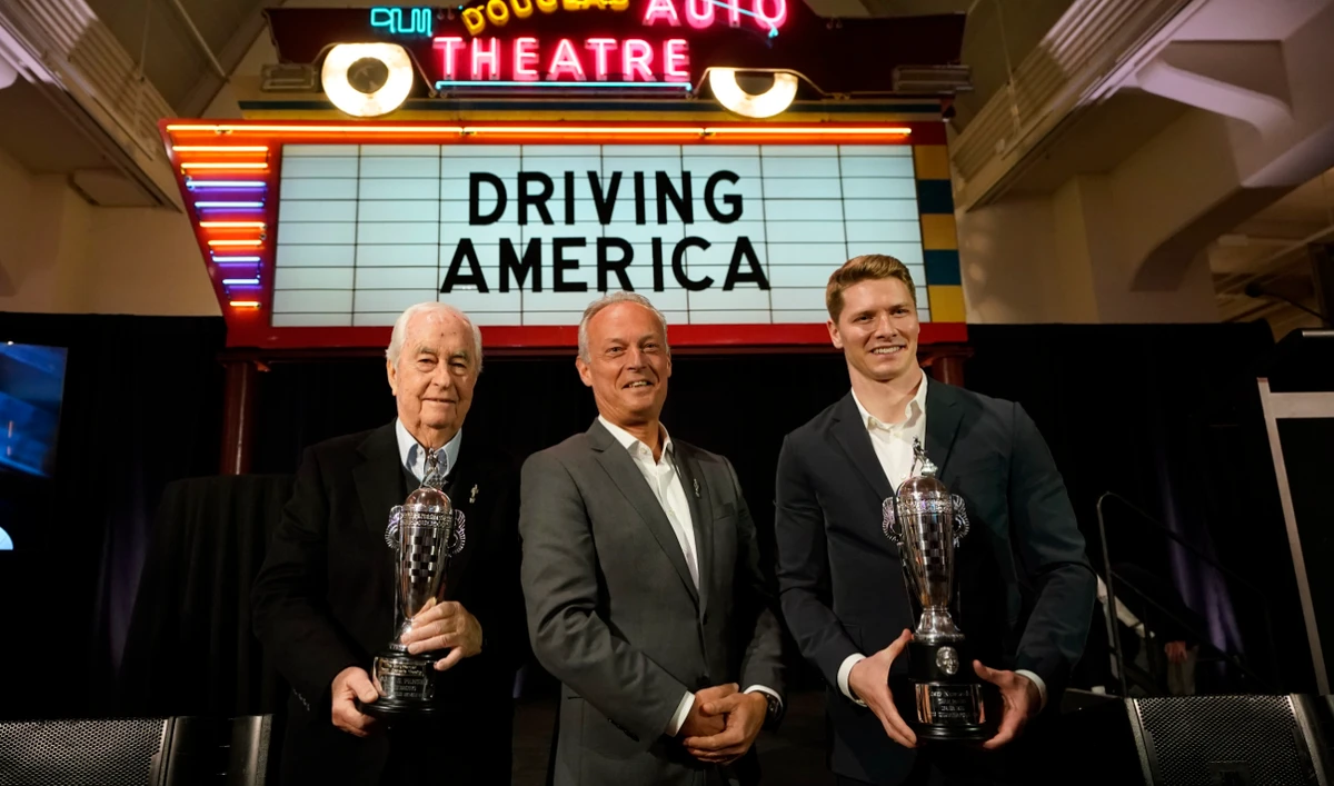 Fred Lissalde, center, president and CEO of BorgWarner; Roger Penske, team owner, left, and driver Josef Newgarden, right, winner of the 2023 Indianapolis 500, hold their Baby Borg driver's and team owner's trophies, Tuesday in Dearborn, Mich. (AP)