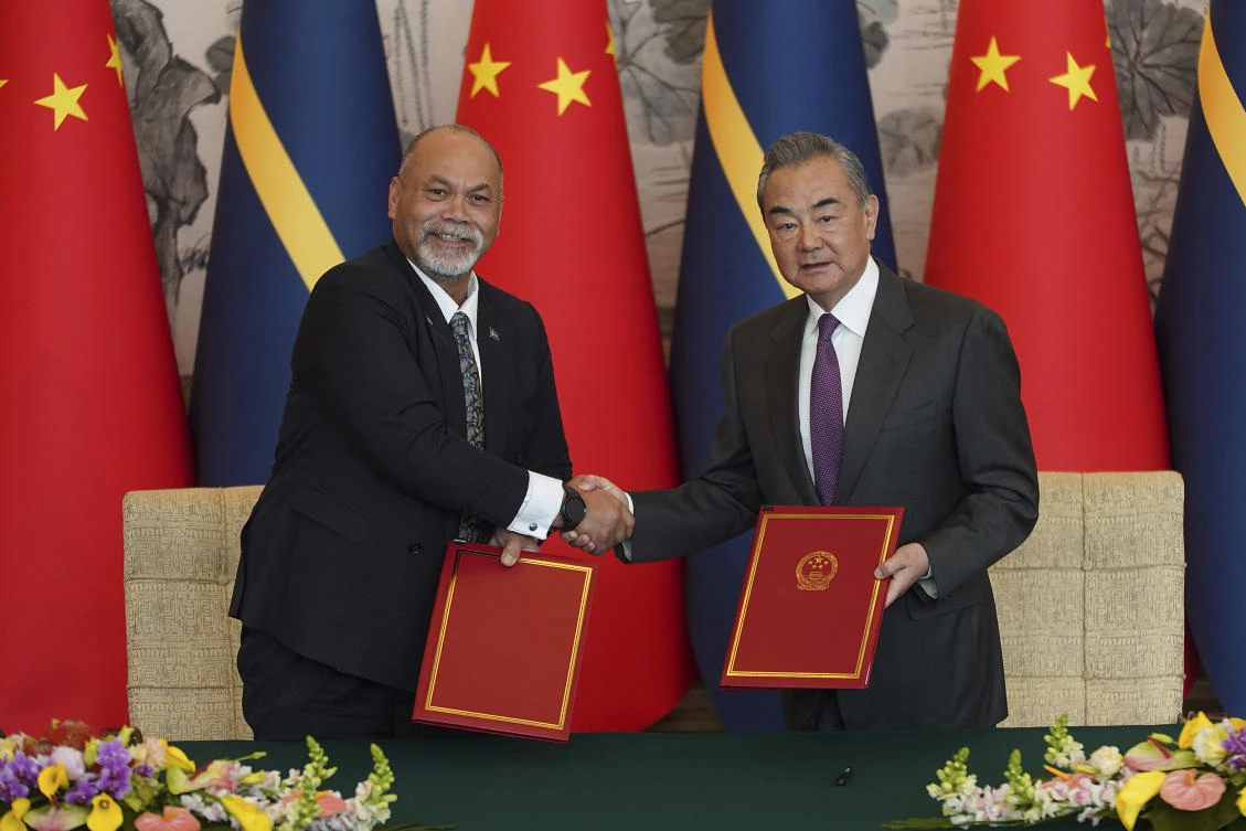 Chinese Foreign Minister Wang Yi, right and Minister of Foreign Affairs and Trade of Nauru Lionel Aingimea shake hands after signing a joint communique on the resumption of diplomatic relations between China and Nauru. (AP)