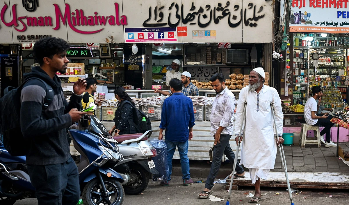 Pedestrians walk past shops along a crowded street near Minara Masjid mosque in Mumbai, India, on January 25, 2024. (AFP)
