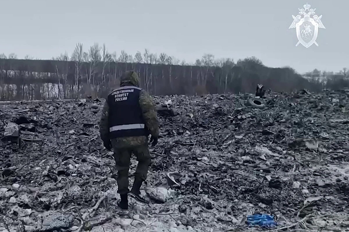 In this grab taken from a handout footage released by the Russian Investigative Committee on January 25, 2024, an investigator works at the military transport plane crash site in the Belgorod region of Russia. (AFP)