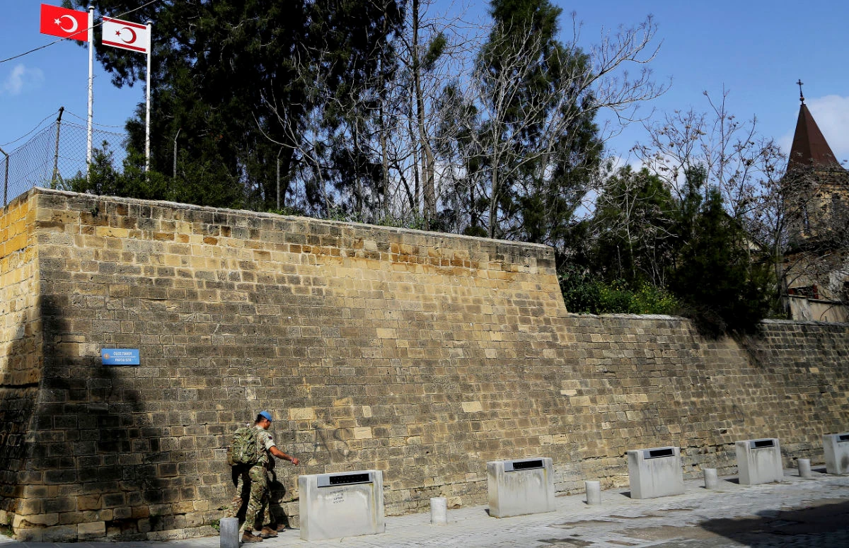 A Turkish, left, and Turkish Cypriot breakaway flag are seen at a Turkish military area at the north part of the city, in the U.N buffer zone that divide the Greek, south, and the Turkish Cypriots, north, controlled areas in divided capital Nicosia, Cyprus, Tuesday, Feb. 26, 2019. (AP)
