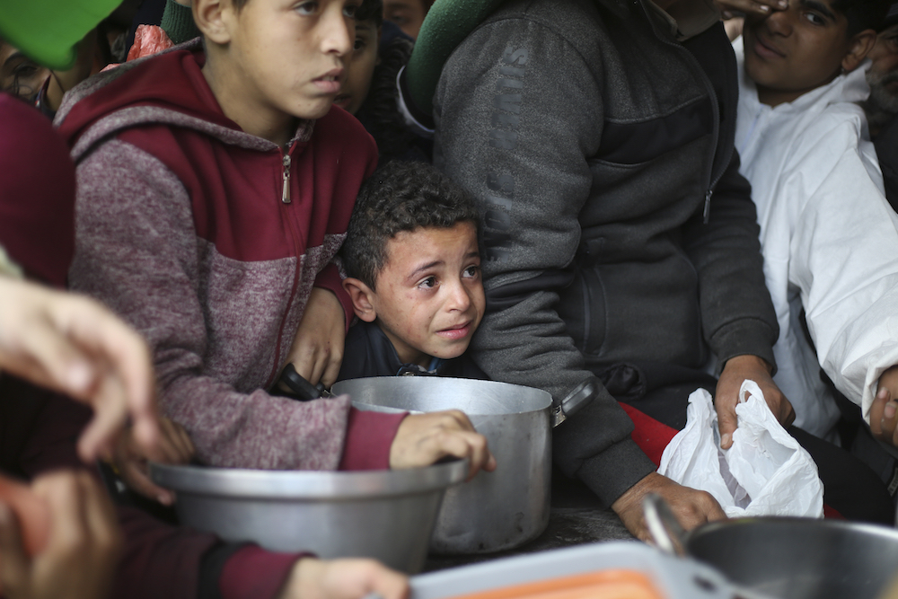 Palestinians line up for free food distribution during the ongoing Israeli air and ground offensive in Khan Younis, Gaza Strip, Friday, Feb. 2, 2024. (AP)