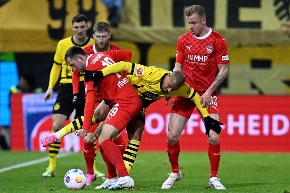 Heidenheim's German defender Jonas Foehrenbach (C) and Dortmund's Dutch forward Donyell Malen vie for the ball during their Bundesliga match in Heidenheim on Feb. 2, 2024. (AFP)