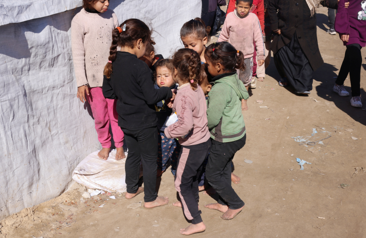 Barefooted displaced Palestinian children, who fled their houses due to Israeli strikes, play at a tent camp, amid shortages of new footwear, in Rafah in the southern Gaza Strip January 31, 2024. (REUTERS)