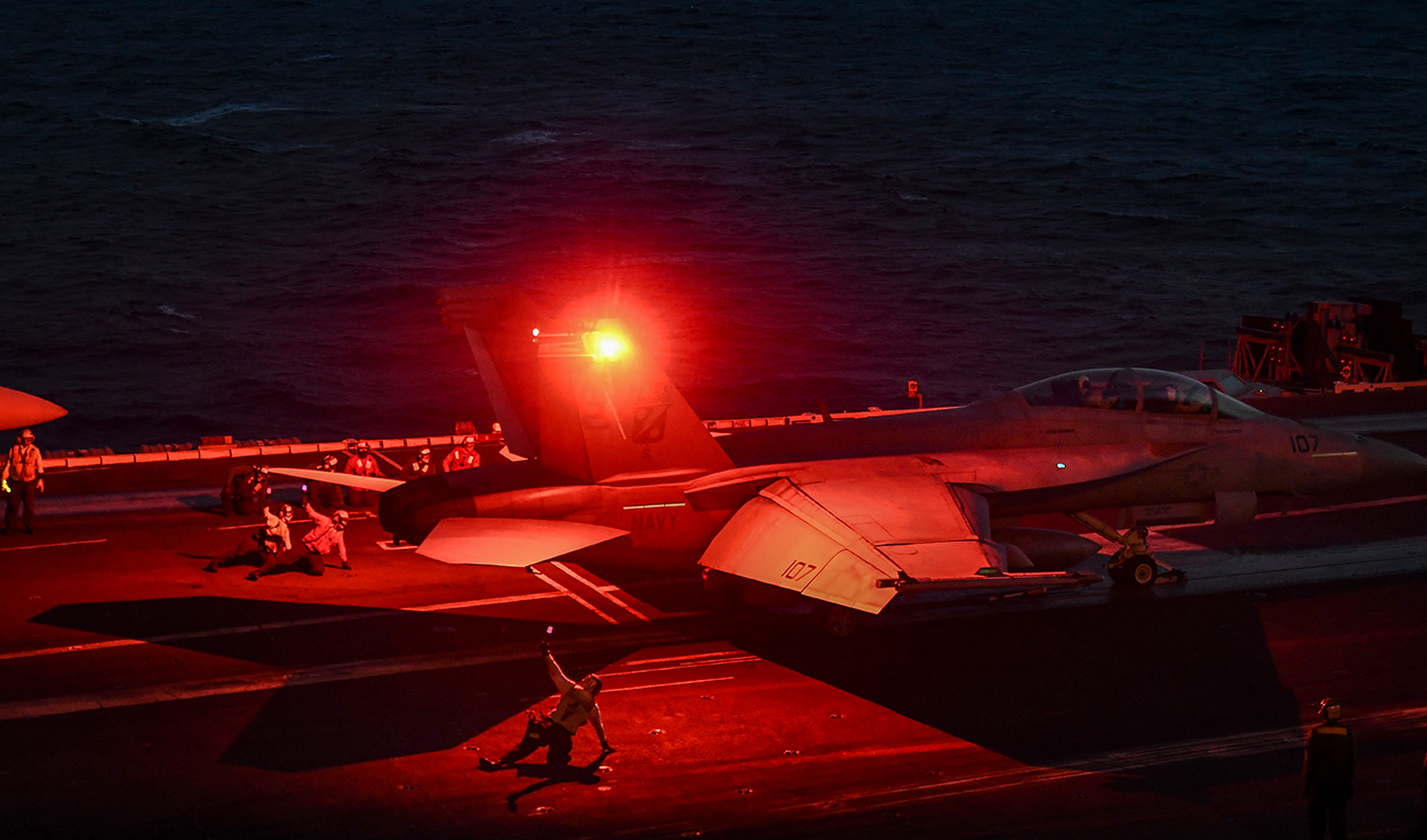 A crew member gestures as a F18 Hornet fighter jet waits to take off from the deck of the 330 meters US navy aircraft carrier the USS Harry S. Truman in the eastern Mediterranean Sea on May 8, 2018. (AFP/File)