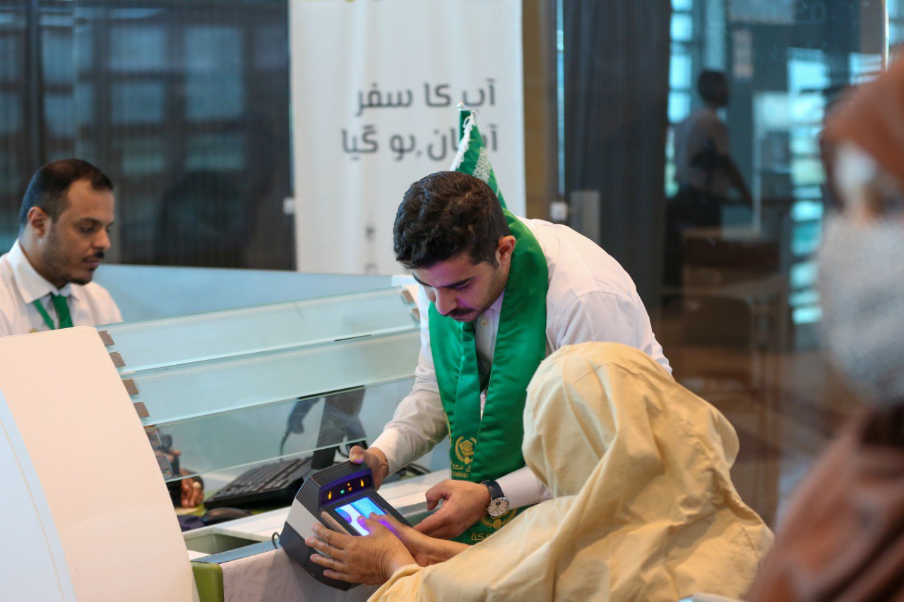 In this file photo, taken on June 13, 2023, a Saudi official facilitates Pakistani Hajj pilgrim during biometrics at the immigration counter on the Makkah Route counter set up at the Islamabad International Airport.(X/@MakkahRoute)