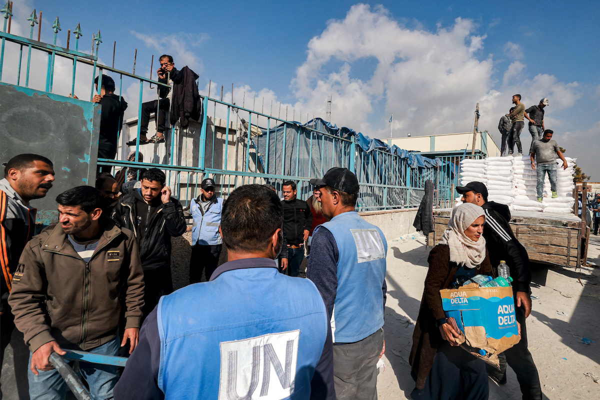 UN workers hand out flour rations and other supplies to people at an UNRWA warehouse in Rafah in the southern Gaza Strip. (File/AFP)