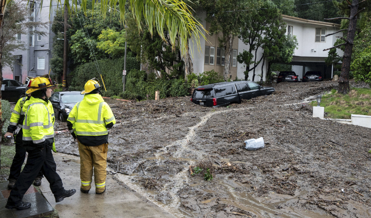 Firefighters look over damage from a large mudslide which occurred at the intersection of Beverly Drive and Beverly Place in the Beverly Crest area of Los Angeles on Monday, February 5, 2024. (AP)
