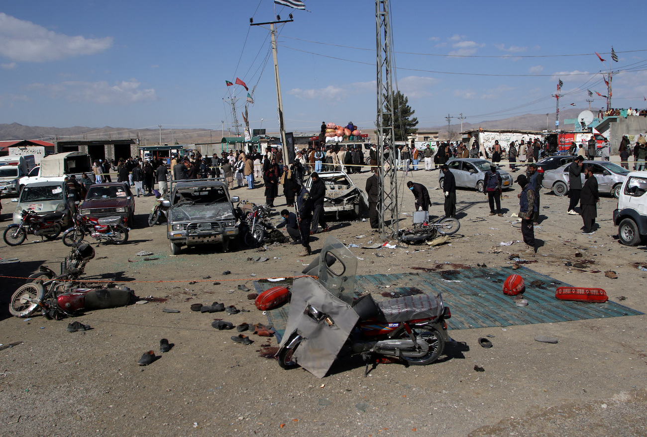 Members of a bomb disposal squad examine the site of a blast in Khanozai, Balochistan, Pakistan, February 7, 2024. (Reuters)