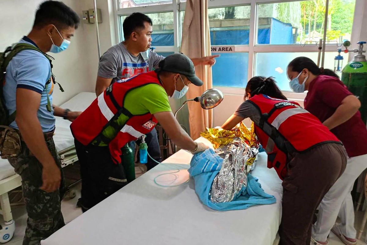 Rescuers provide medical attention to a child at the Doctors Community Hospital in Mawab, Davao de Oro, following her rescue nearly 60 hours after a landslide hit a gold-mining village in the southern Philippines (AFP)