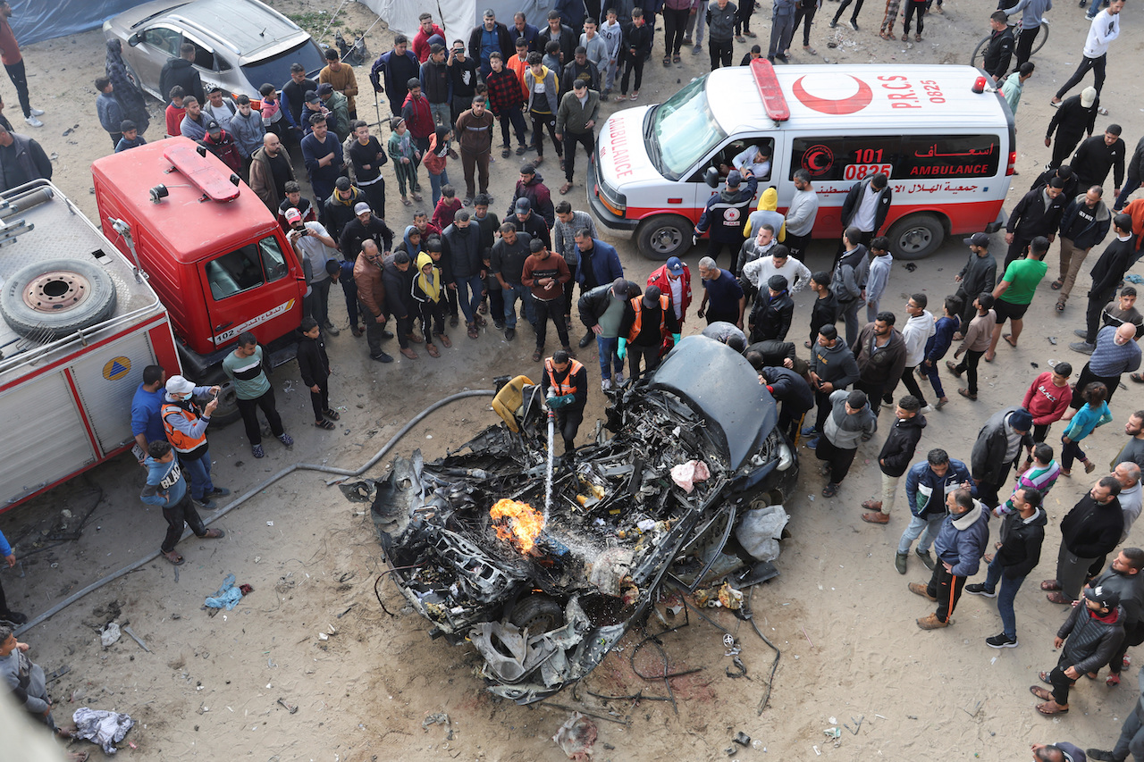 Palestinians inspect a car hit by an Israeli strike, amid the ongoing conflict between Israel and Palestinian Islamist group Hamas, in Rafah in the southern Gaza Strip, February 10, 2024. (Reuters)