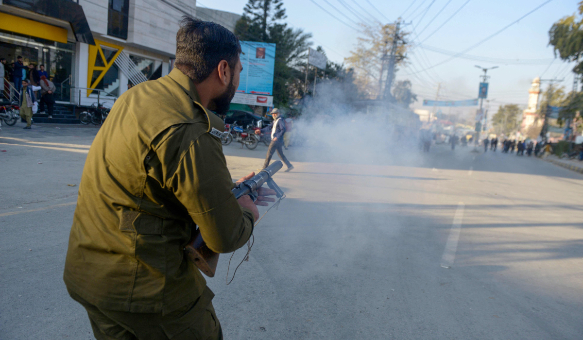 A policeman fires tear gas to disperse supporters of Khan's Pakistan Tehreek-e-Insaf (PTI) party as they protest against the alleged skewing in Pakistan's national election results, in Rawalpindi on February 11, 2024. (AFP)