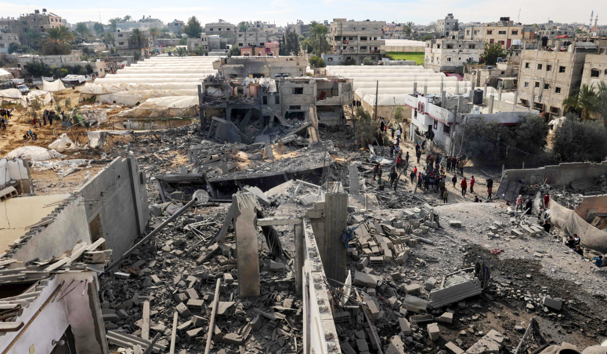 Palestinians inspect the damage amid the rubble of a building where two hostages were reportedly held before being rescued during an operation by Israeli security forcess in Rafah, on the southern Gaza Strip on February 12, 2024, amid ongoing battles between Israel and the militant group Hamas. (AFP)