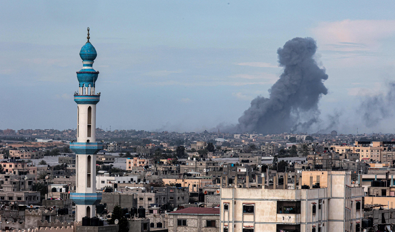 This picture taken from Rafah shows smoke billowing over Khan Yunis in the distance following Israeli bombardment on the southern Gaza Strip on February 14, 2024, amid the ongoing conflict between Israel and the Palestinian Hamas group. (AFP)