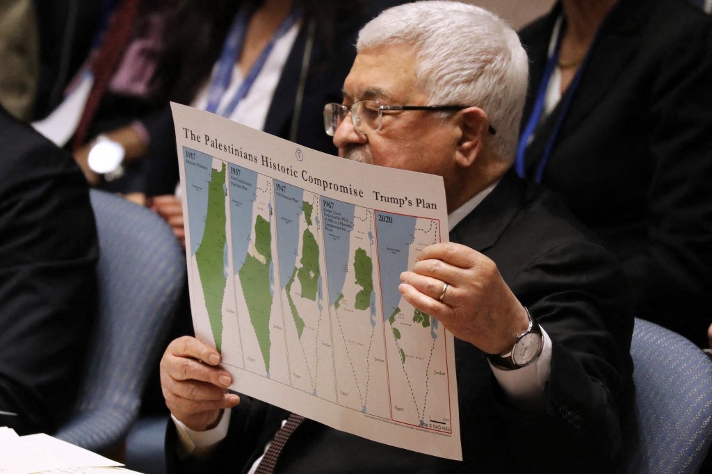 Palestinian President Mahmoud Abbas holds up a Vision for Peace map while speaking at the United Nations (UN) Security Council on February 11, 2020 in New York City (AFP)