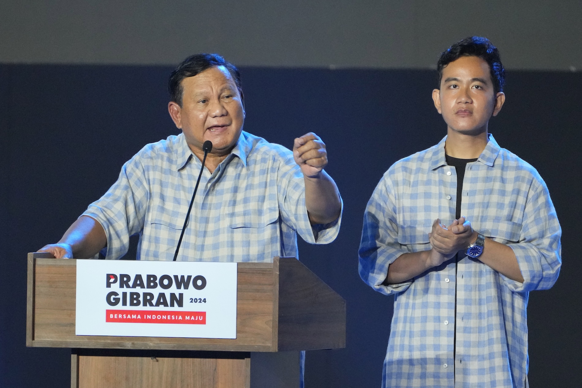 Indonesian Defense Minister and presidential candidate Prabowo Subianto, left, speaks to supporters and members of his campaign team alongside his running mate, Gibran Rakabuming Raka in Jakarta, on Feb. 14, 2024. (AP)