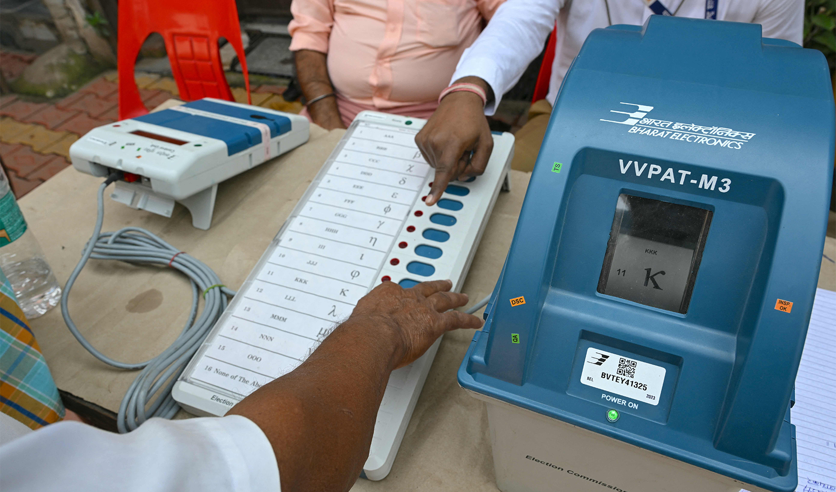Indian election official (R) demonstrates the use of the Voter Verifiable Paper Audit Trail (VVPAT) to citizens at an awareness camp in Mumbai on February 15, 2024, ahead of India's upcoming parliamentary elections. (AFP)