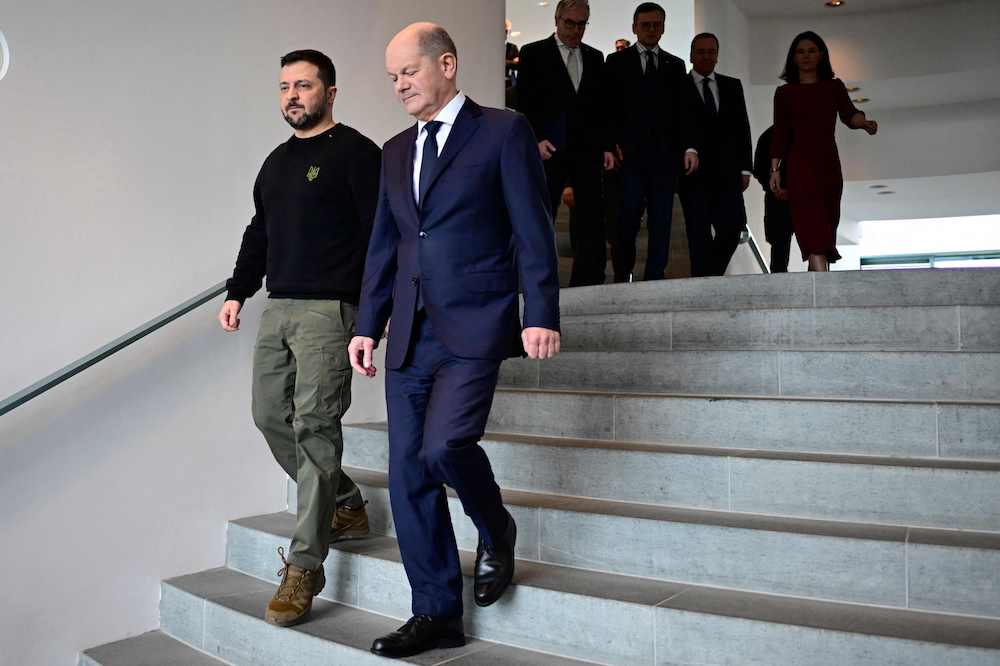 German Chancellor Olaf Scholz (R) and Ukraine's President Volodymyr Zelensky arrive with ministers to sign a bilateral security agreement the Chancellery, on February 16, 2024 in Berlin, Germany. (AFP)
