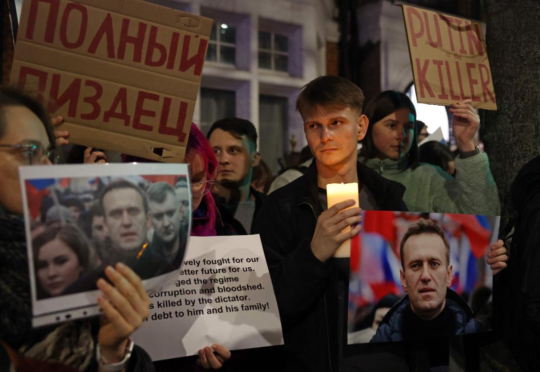 People hold up photographs of Russian opposition leader Alexei Navalny at a gathering outside the Russian Embassy in London on Feb. 16, 2024, following the news of his death. (AFP)