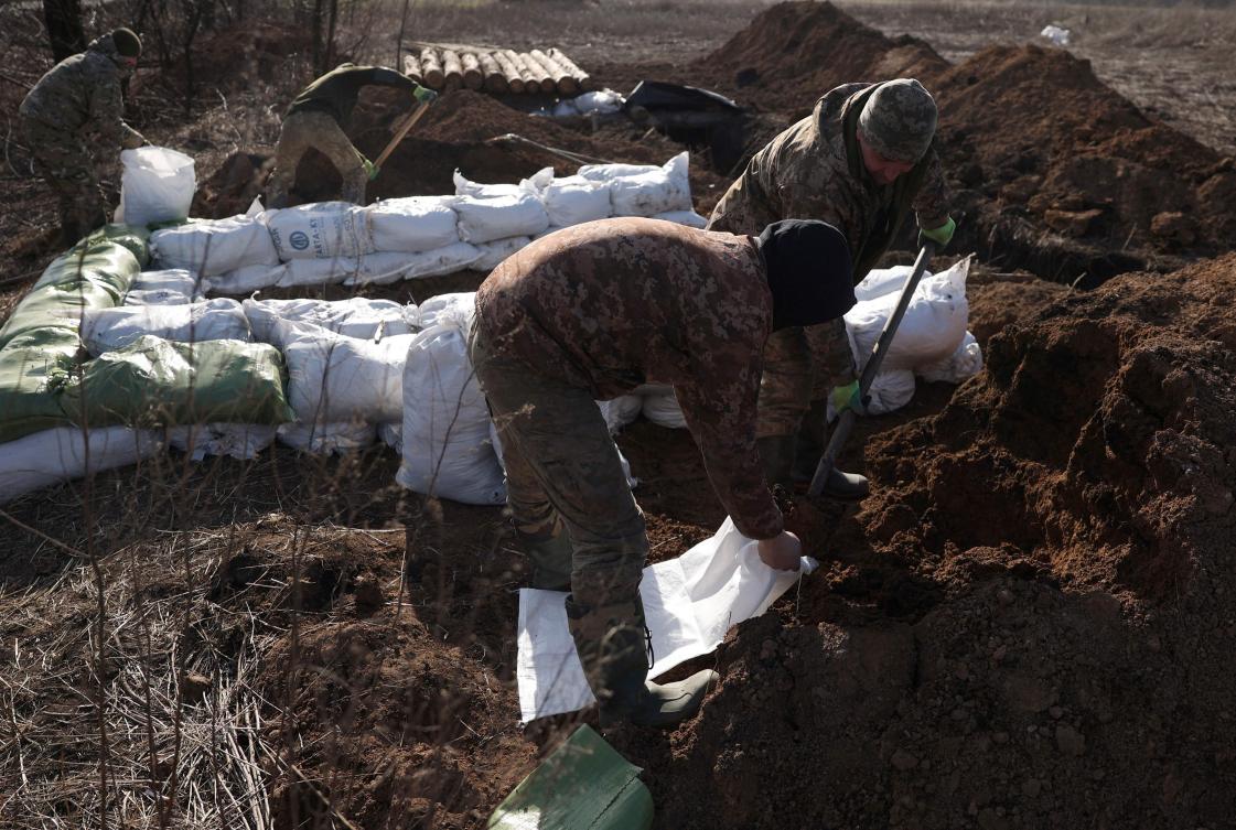 Ukrainian servicemen prepare earthbags to build a fortification not far from town of Avdiivka in the Donetsk region on Feb. 17, 2024. (AFP)