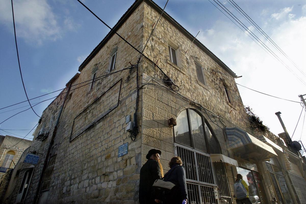 A couple of Orthodox Jews walk in front of a house at Jerusalem street in the Galilee town of Safed. (File/AFP)