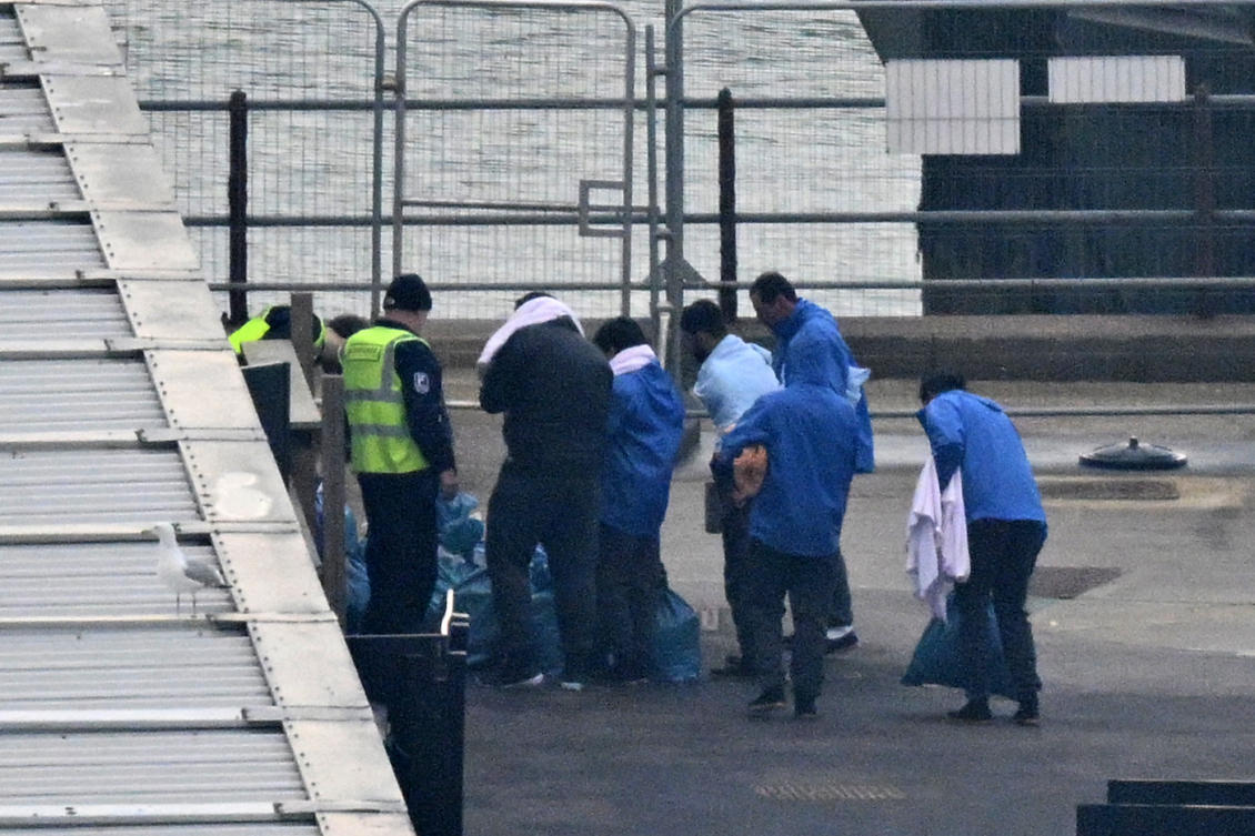 UK Border Force and Interforce security officers escort migrants at the Marina in Dover southeast England. (File/AFP)