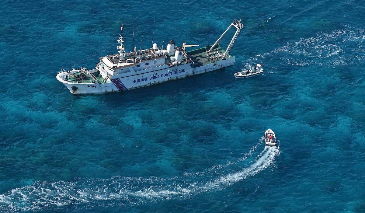 This photo taken on February 15, 2024, shows an aerial view of an China Coast Guard vessel (upper) and China Coast Guard personnel on a rubber boat at Scarborough Shoal in the disputed South China Sea. (AFP)