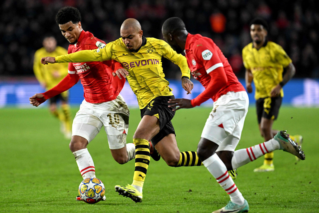 PSV's US midfielder Malik Tillman (L) and Dortmund's Dutch forward Donyell Malen (C) fight for the ball during the UEFA Champions League round of 16, first leg football match between against PSV Eindhoven and Borussia Dortmund at the The Philips Stadium, in Eindhoven on February 20, 2024. (AFP)