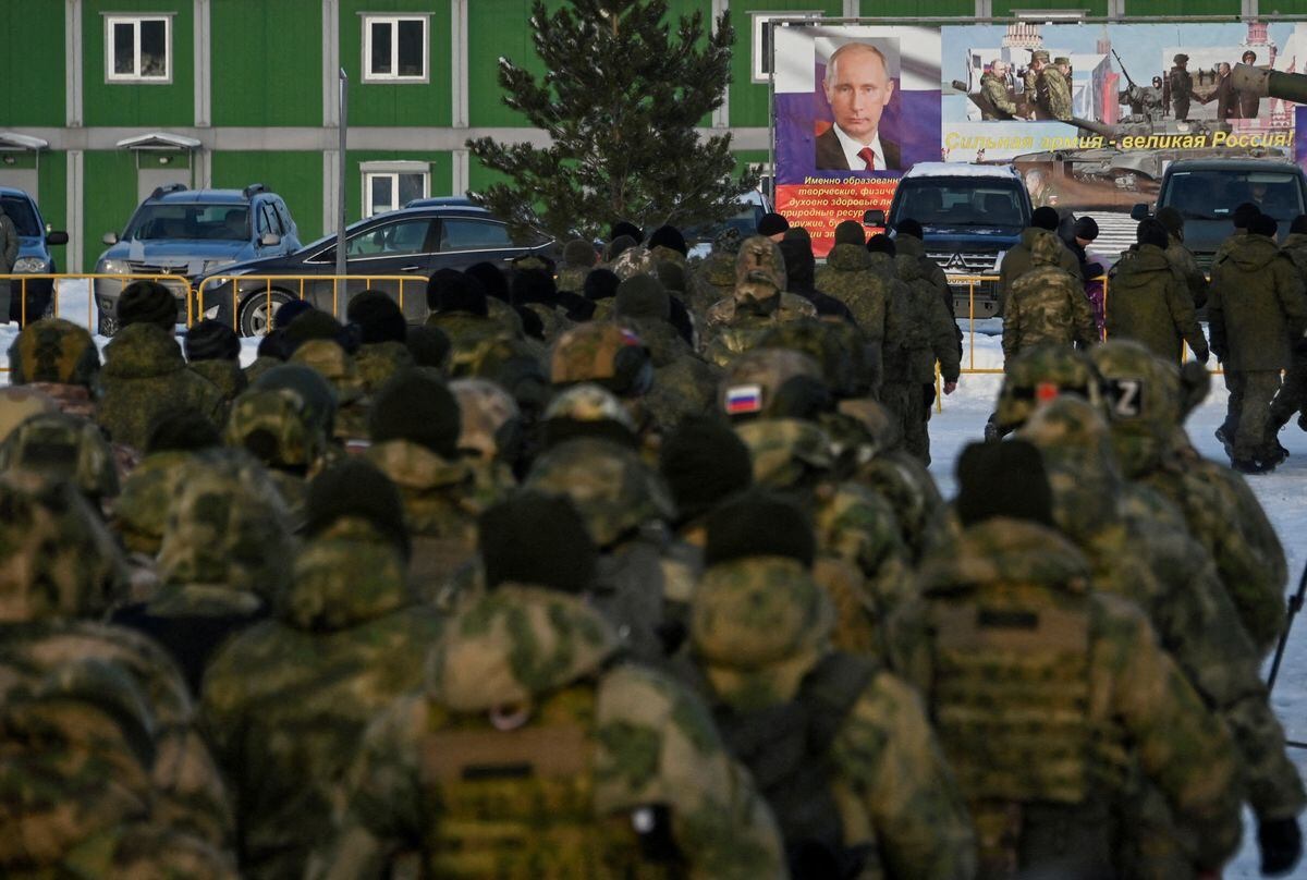 Russian reservists recruited during a partial mobilization of troops walks towards a banner with a portrait of Russian President Vladimir Putin in Omsk, Russia Jan. 6, 2023. (REUTERS)
