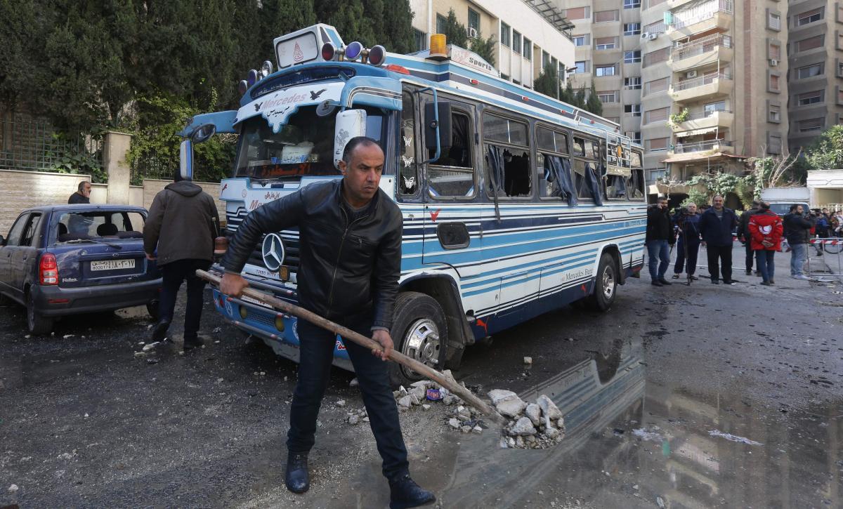 A man clears the rubble in the area where reported Israeli air strikes targeted a residential building in the Kafr Sousa district of Damascus on February 21, 2024. (File/AFP)