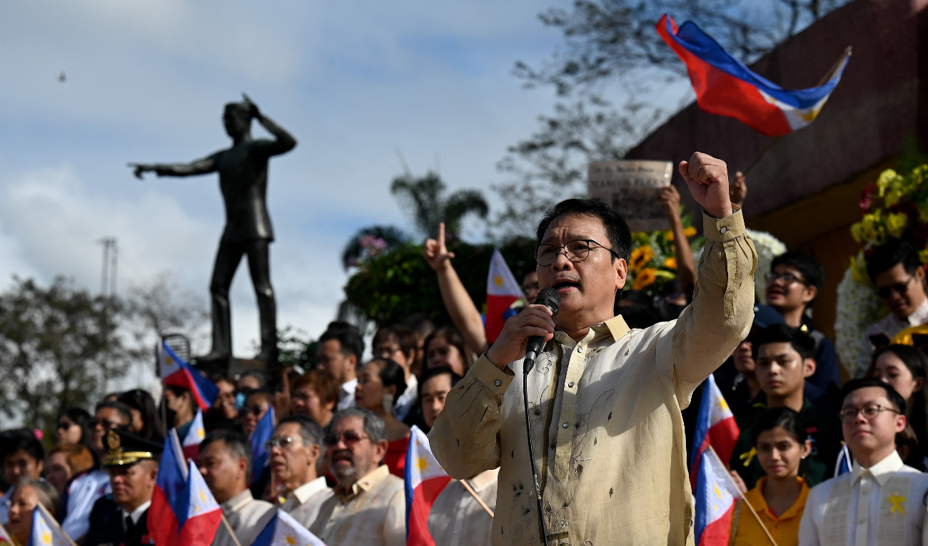 A man talks after the wreath laying in front of the People Power Monument during the 38th anniversary of the “People Power” revolution, which ousted Philippine President Ferdinand Marcos Jr’s dictator father and sent the family into exile, on Epifanio de los Santos Avenue, in Quezon City, metro Manila on February 25, 2024.
