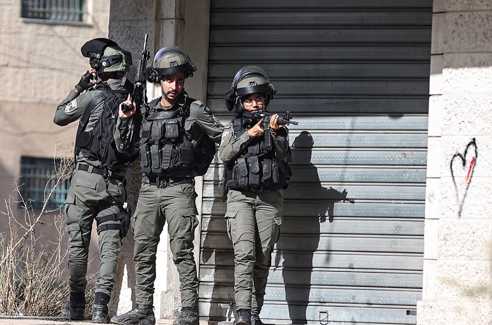 Members of the Israeli border police take positions during a raid. (AFP/File)