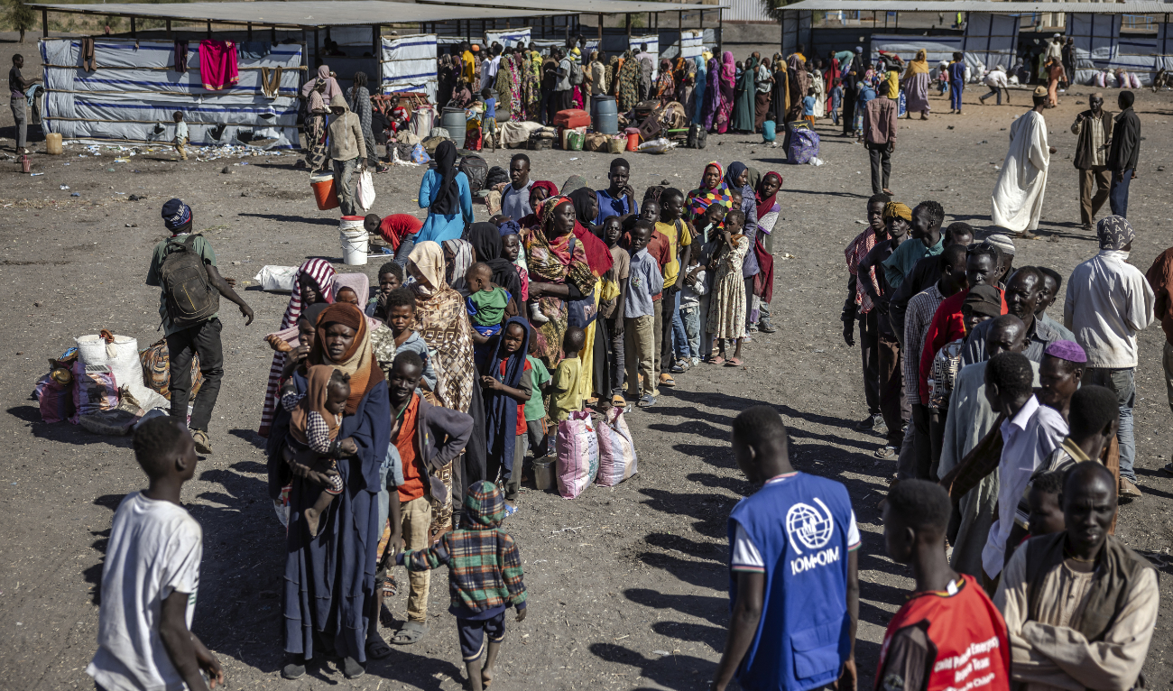 Sudanese refugees and South Sudanese families who have fled from the war in Sudan line up while waiting to board a truck to go to a Transit Centre for refugees after crossing the border at the Joda Border Crossing Point, near Renk, on February 14, 2024. (AFP/File)