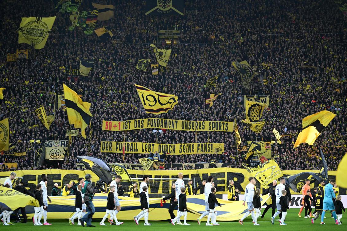 Borussia Dortmund fans display a banner ‘(The) 50+1 (rule) is the foundation of our sport’ prior to their Bundesliga match against TSG 1899 Hoffenheim in Dortmund on Feb. 25, 2024. (AFP)