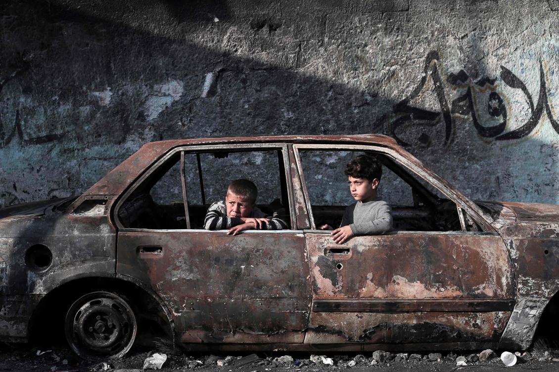 Children sit in a destroyed car in Rafah, on the southern Gaza Strip on February 28, 2024, amid ongoing battles between Israel and the Palestinian militant group Hamas. (AFP)
