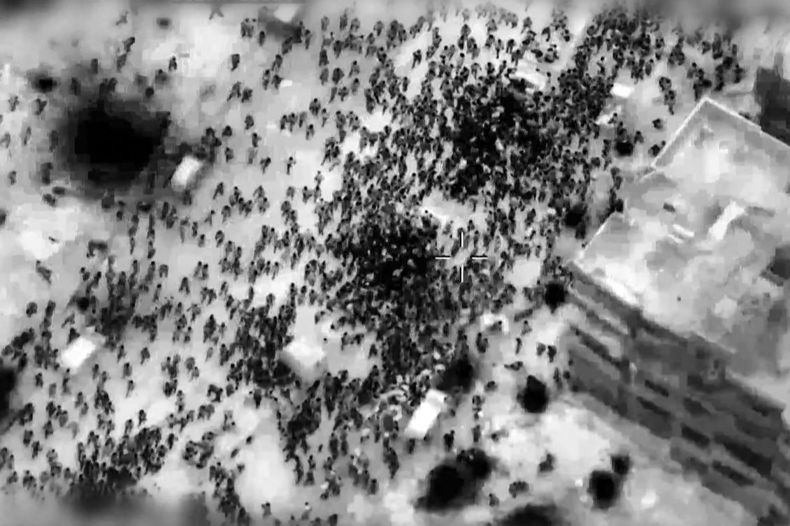 This image grab from a handout video released by the Israeli army on Feb. 29, 2024, shows what the army says are Gazans around aid trucks in Gaza City. (AFP)