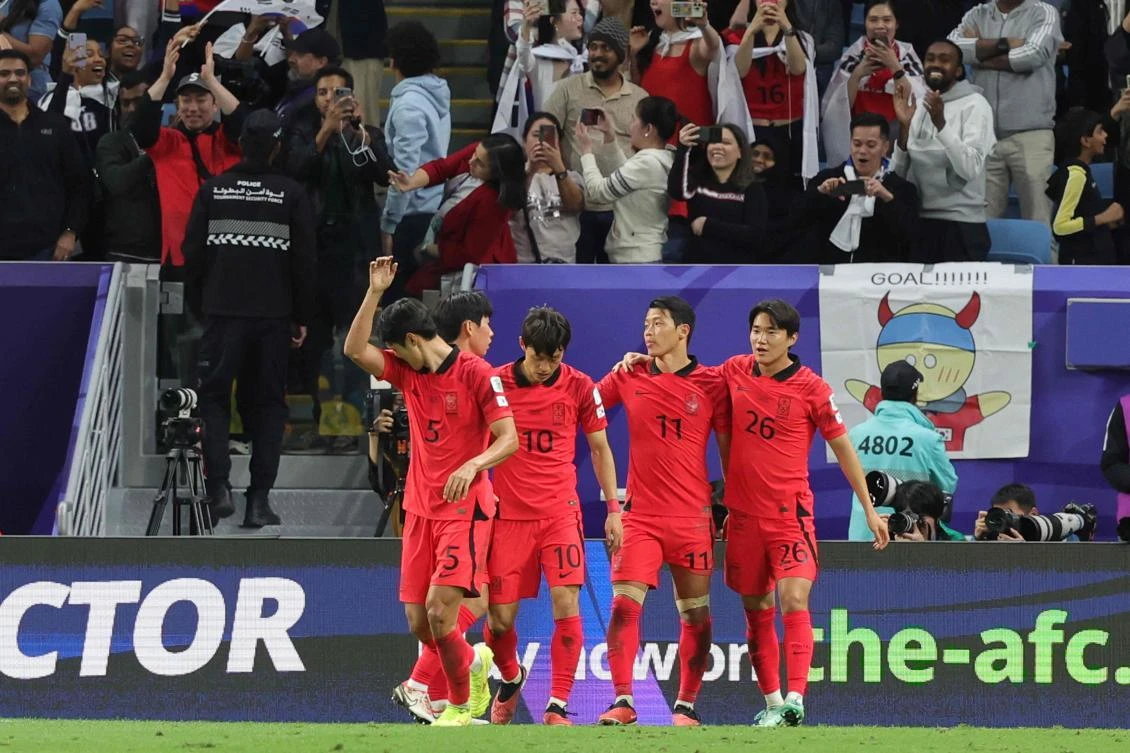 South Korea’s midfielder Hwang Hee-chan celebrates with teammates after scoring his team’s first goal during their Qatar 2023 AFC Asian Cup quarter-final match against Australia at Al-Janoub Stadium in Al-Wakrah, Doha, on Feb. 2, 2024. (AFP)