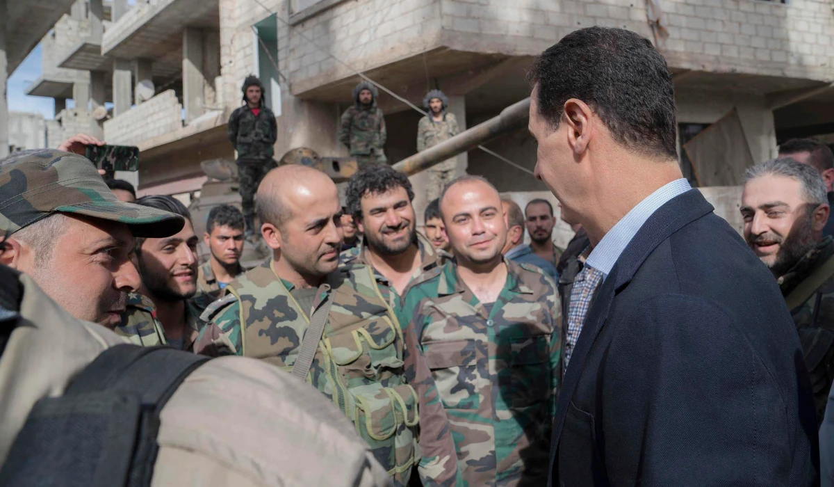 Syrian President Bashar Assad, right, speaks with Syrian troops during his visit to eastern Ghouta, near the capital Damascus, Syria. (AP file photo)