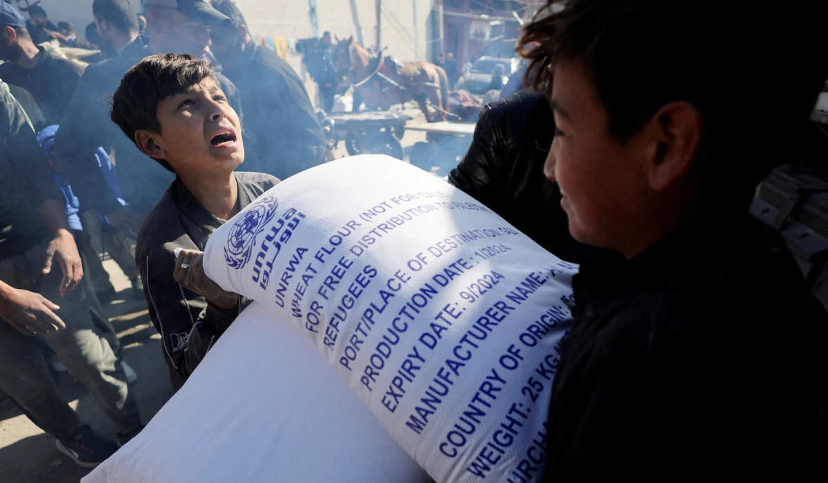 Palestinians gather to receive bags of flour distributed by the United Nations Relief and Works Agency (UNRWA), amid the ongoing conflict between Israel and Palestinian Islamist group Hamas, in Rafah in the southern Gaza Strip February 1, 2024. (REUTERS)