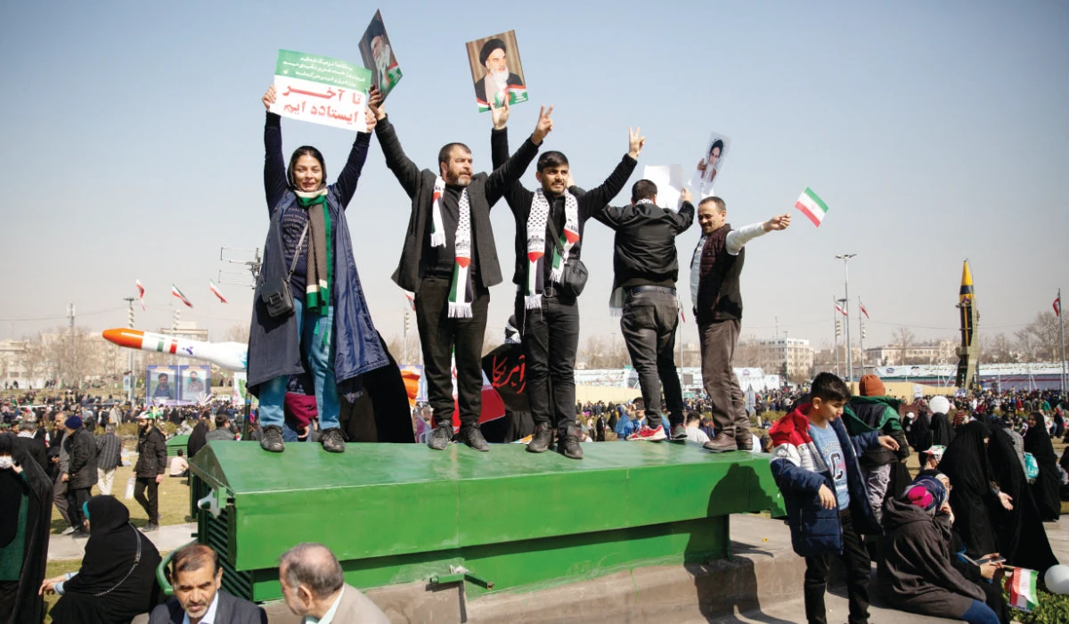 Crowds in Tehran’s Azadi Square hold up portraits of the supreme leader, Ayatollah Ali Khamenei, as well as of the founder of the Islamic republic, Ayatollah Ruhollah Khomeini, at Sunday’s rally. (Reuters)