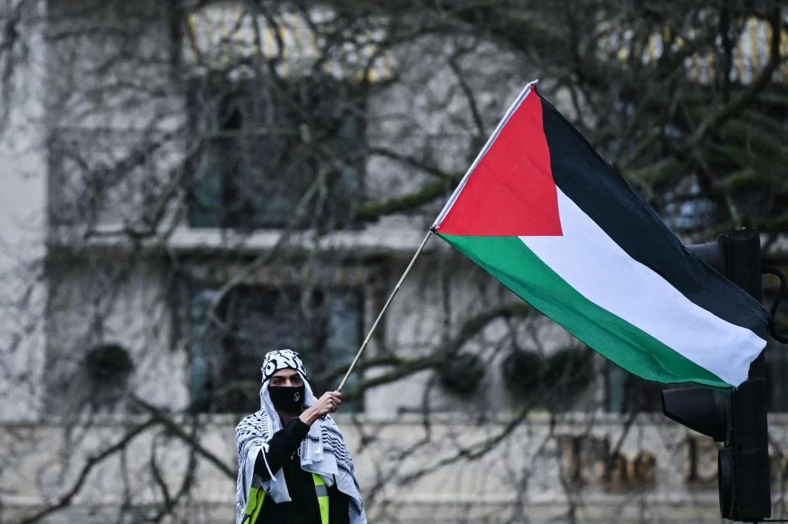 A Pro-Palestinian supporter waves a Palestinian flag during a National March for Palestine in central London on Feb. 17, 2024. (AFP)