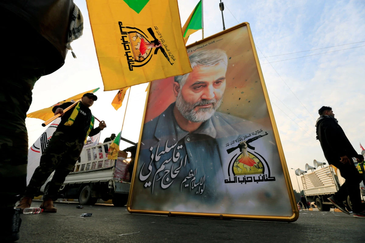 Kataib Hezbollah Iraqi militia display the picture of the Iranian Major-General Qassem Soleimani as they gather ahead of the funeral of the Iraqi militia commander Abu Mahdi al-Muhandis, who was killed in an air strike at Baghdad airport on January 4, 2020. (REUTERS)